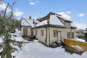 View of snow covered exterior with a deck