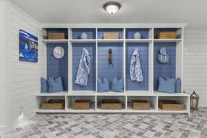 Mudroom featuring wooden walls