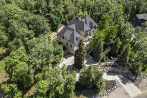 Aerial view of property and surrounding area featuring a forest