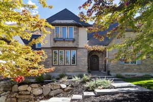 View of front of property featuring stone siding and a high end roof