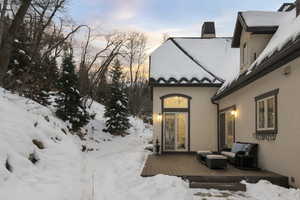 Snow covered property entrance featuring a wooden deck