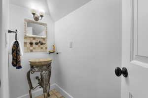 Bathroom featuring tile patterned floors and lofted ceiling