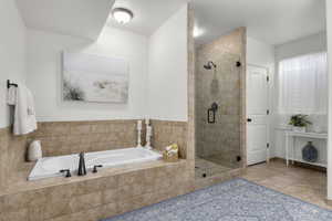 Bathroom featuring tile patterned floors and plus walk in shower