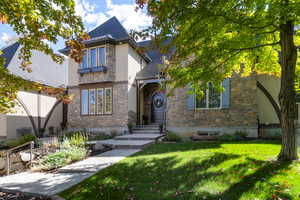 View of front facade with a front yard and stone siding
