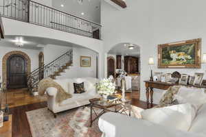 Living room with a high ceiling and dark hardwood / wood-style flooring