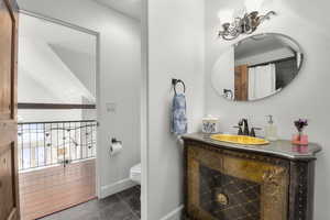 Bathroom with toilet, tile patterned floors, and vanity