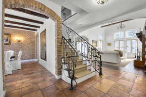 Staircase featuring beam ceiling and a chandelier