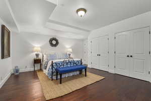 Bedroom featuring dark hardwood / wood-style flooring and multiple closets