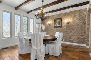 Dining area featuring an inviting chandelier and beamed ceiling