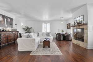 Living room with a fireplace and dark hardwood / wood-style flooring