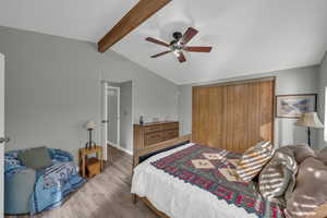 Bedroom with lofted ceiling with beams, light wood-type flooring, ceiling fan, and a closet