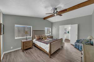 Bedroom featuring ceiling fan, lofted ceiling with beams, and light hardwood / wood-style flooring