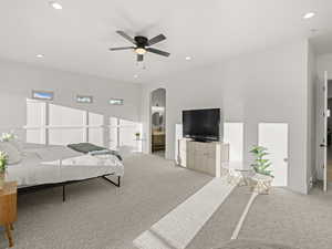 Carpeted bedroom featuring ensuite bathroom and ceiling fan