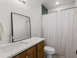 Bathroom featuring vanity, toilet, and a textured ceiling