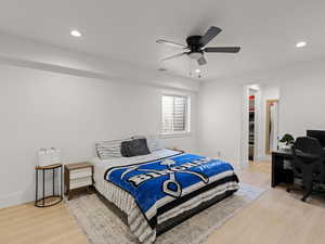 Bedroom with a spacious closet, light hardwood / wood-style floors, a closet, and ceiling fan