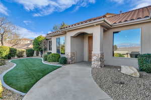 Doorway to property with a lawn