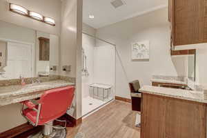 Bathroom featuring hardwood / wood-style flooring, walk in shower, and vanity