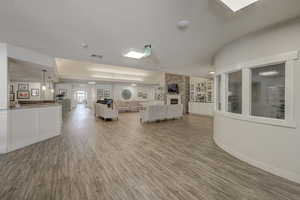 Unfurnished living room with hardwood / wood-style flooring, a textured ceiling, built in features, and a fireplace