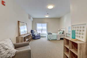 Bedroom featuring a wall unit AC and carpet