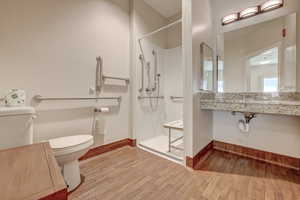 Bathroom featuring hardwood / wood-style floors, toilet, and walk in shower