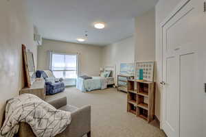 Carpeted bedroom featuring a wall unit AC