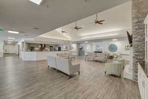 Living room featuring light hardwood / wood-style floors, lofted ceiling, and a fireplace