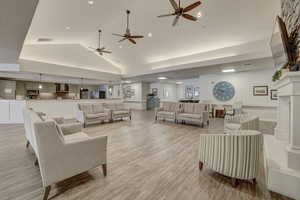 Living room featuring light hardwood / wood-style floors, a high end fireplace, and vaulted ceiling