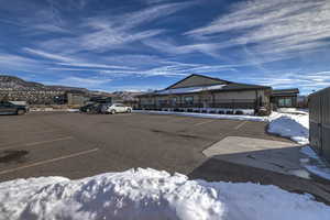 Snow covered parking area featuring a mountain view