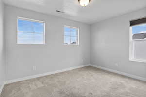 Unfurnished room with light carpet and a textured ceiling