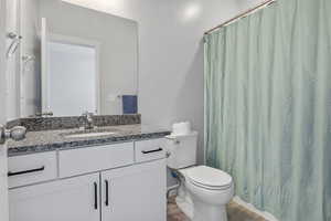 Bathroom featuring vanity, toilet, curtained shower, and hardwood / wood-style floors