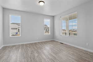 Empty room featuring light hardwood / wood-style flooring and a textured ceiling