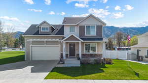 Craftsman-style house featuring fence, a mountain view, driveway, and a front yard