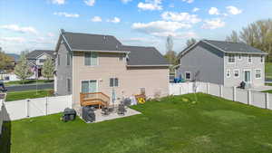Back of property featuring a fenced backyard, a gate, a lawn, and a patio area
