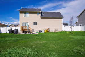 Rear view of property featuring a fenced backyard, a gate, a patio, and a yard