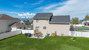 Rear view of property with a lawn, a patio, a gate, and a fenced backyard