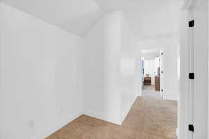 Hallway with light colored carpet desk area