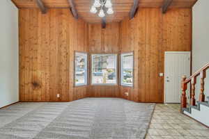 Entrance foyer featuring wood ceiling, beam ceiling, and a notable chandelier