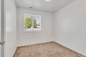 Unfurnished room featuring light carpet