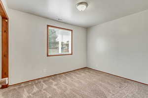 Empty room featuring light colored carpet