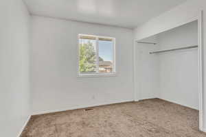 Unfurnished bedroom featuring light colored carpet and a closet