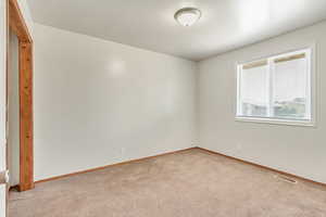 Spare room featuring light colored carpet