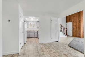 Kitchen with sink, wooden walls, and white refrigerator