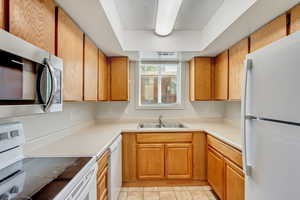 Kitchen featuring white appliances and sink