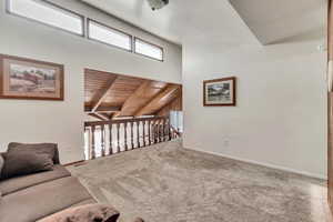 Living room with wood ceiling, carpet flooring, and beam ceiling