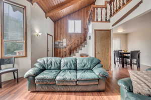 Living room featuring hardwood / wood-style floors, wood ceiling, plenty of natural light, and beamed ceiling