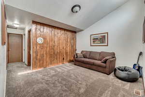 Carpeted living room featuring lofted ceiling