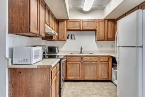 Kitchen featuring sink and white appliances