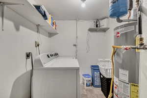 Washroom with water heater and washing machine and dryer