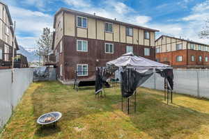 Back of property featuring a gazebo, an outdoor fire pit, a yard, and a mountain view