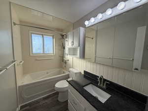 Full bathroom featuring tiled shower / bath, backsplash, hardwood / wood-style flooring, vanity, and toilet